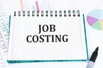JOB COSTING text on notepad on the background of documents on the table