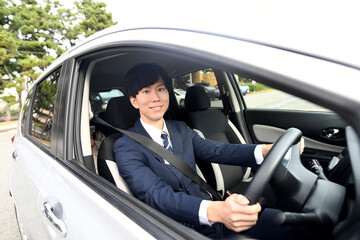 車を運転するスーツ姿のビジネスマン