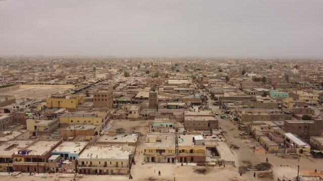 Aerial drone shot of yhe Nouakchott city, going down and showing a wide view of hte cityscape
