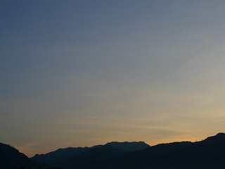 Silhouette of mountain with blue sky at sunrise  ,Horizon began to turn orange with gold color in tropical areas, Thailand