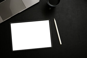 Top view, Digital tablet mockup, stylus pen, coffee cup and laptop are on black tabletop background.