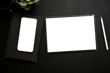 Workspace with smartphone and tablet mockup and decor on black background. top view