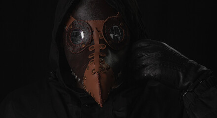 Fototapeta na wymiar Dark horror figure in black hood in plague doctor mask