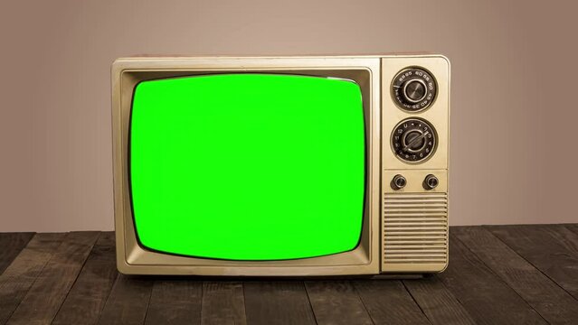 Vintage TV with green screen on wooden table