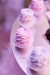 Close-up of bright pink cupcakes on a mirrored stand.