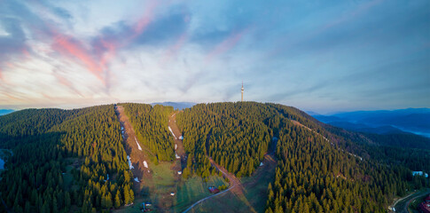 Snezhanka tower in valley of Rhodope mountains and forests against clouds. Panorama, top view