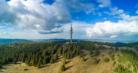 Snezhanka tower in valley of Rhodope mountains and forests against clouds. Panorama, top view