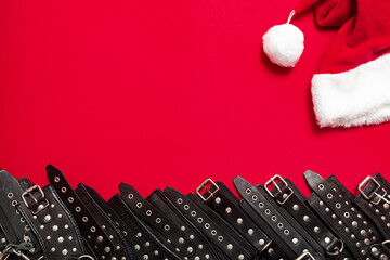 Red color banner with black leather bracers and metal rivets for shackling hands or legs and performing sexual games. BDSM subject. Background for advertising adult products and sex toy store