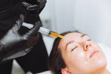 Plasma injection into the hair on a woman 's head .a cosmetologist makes plasma injections into the...