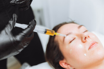 Plasma injection into the hair on a woman 's head .a cosmetologist makes plasma injections into the...