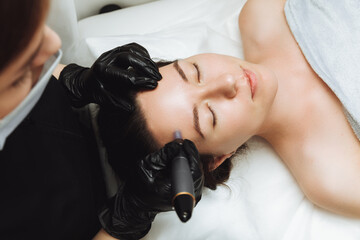 Cosmetic mesotherapy for facial rejuvenation. Cosmetic procedure of microneedling. The...