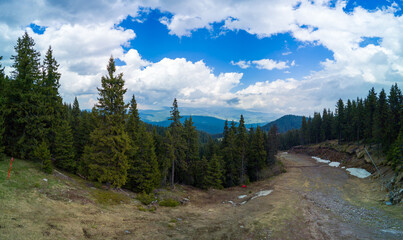 Mountain descent through forest in Rhodope Mountains against sky in weather. Panorama, top view