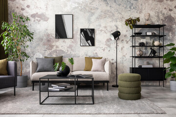 Interior design of concrete living room with mock up poster frame, stylish gray sofa, patterned pillows, simple black coffee table, round vase with dried flowers, cup, plants in flowerpot Home decor. 