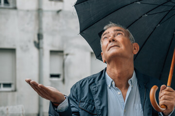 middle-aged man with umbrella in the street