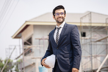 Portrait of an architect builder studying layout plan of the rooms, serious civil engineer working...