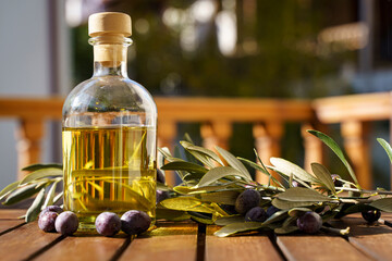 Olive oil with olive tree branch background. Natural oil for food or cosmetics from natural...