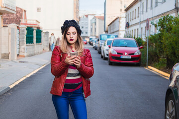 Fototapeta premium young woman using smart phone in the street