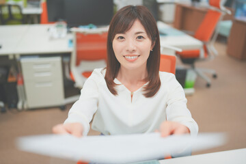 オフィスで書類を渡す女性社員