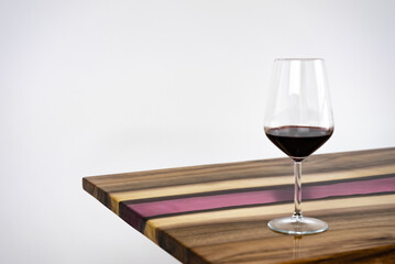 Coffee table, living room table. Resin handmade wood table. On a white background. Glass of whisky and glass of wine on the table.