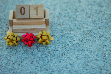 Calendario vintage de madera con la fecha de año nuevo y lazos de regalos de navidad de colores...