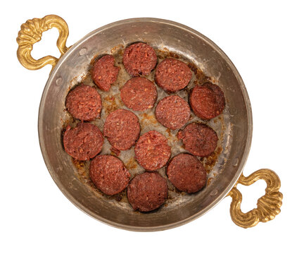 Fried sausage, top view photo of traditional Turkish fried sausage called sucuk. Isolated on white. Vintage tinned copper frying pan. Delicious breakfast appetizing dish.