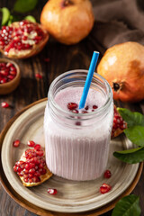 Vegan protein smoothie made from pomegranate and banana on a rustic wooden table. Healthy food, healthy lifestyle. Foodism, raw food diet.