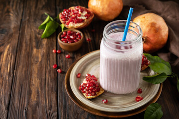 Vegan protein smoothie made from pomegranate and banana on a rustic wooden table. Healthy food, healthy lifestyle. Foodism, raw food diet. Copy space.