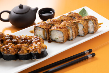 sushi and rolls on an orange background