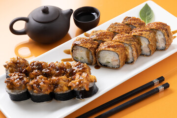 sushi and rolls on an orange background