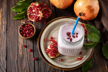 Vegan protein smoothie made from pomegranate and banana on a rustic wooden table. Healthy food, healthy lifestyle. Foodism, raw food diet. Copy space.