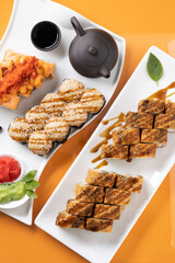 sushi and rolls on an orange background