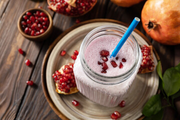 Vegan protein smoothie made from pomegranate and banana on a rustic wooden table. Healthy food, healthy lifestyle. Foodism, raw food diet.