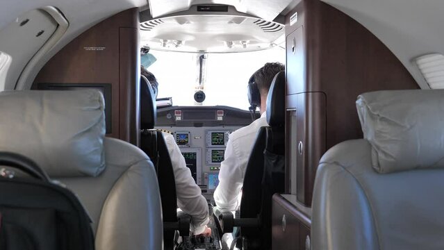 Back View Of Pilot And Co-Pilot In The Cockpit Of A Private Jet Plane. static