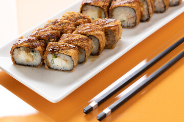 sushi and rolls on an orange background