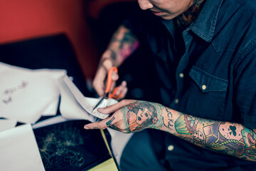Professional tattooist makes the tattoo on a girl in Studio lowlight.