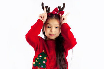 Cute asian kid girl in red clothes fingers pointing up white background.