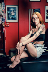 Obraz na płótnie Canvas Portrait of a girl with a tattoo on her shoulder in a modern studio lowlight.