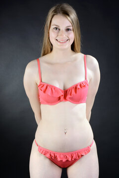 Beautiful young woman posing in red bikini in studio	
