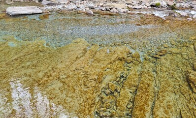 Fondo natural con textura y detalle de remanso de aguas cristalinas sobre fondo de piedra