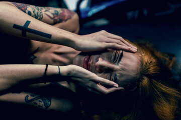 Professional tattooist makes the tattoo on a girl waist, focusing on tattoo machines in a modern studio lowlight.