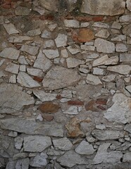 Fondo con detalle y textura de pared de piedras en diferentes formas y tamaños, con tonos marrones y grises