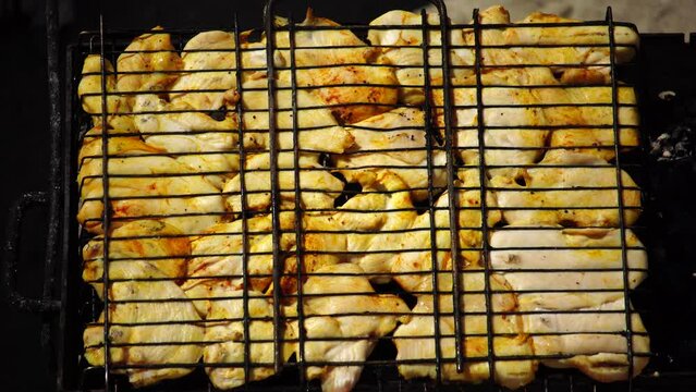 close-up of flattened out barbecued golden crispy skin chicken tabaka on grid, side view from above
