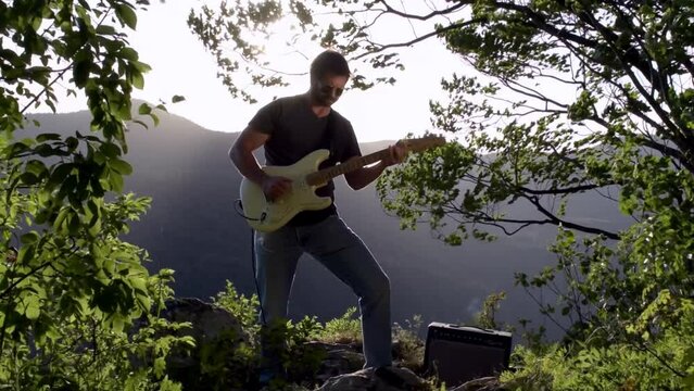 Guitar Player in Nature Behind a Drop