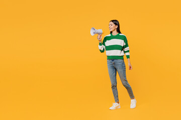 Fototapeta premium Full body young latin woman wear casual green knitted sweater hold scream in megaphone announces discounts sale Hurry up isolated on plain yellow background studio portrait People lifestyle concept.