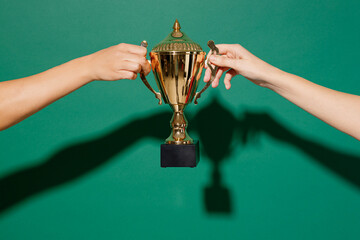 Close up cropped female holding in hand football soccer golden cup isolated on pastel plain light blue color wall background studio. Victory achievement award concept. Copy space advertising mock up.