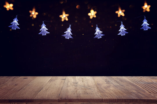 Empty wooden table in front of Christmas garland lights. ready for product presentation