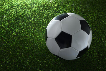 Detail of soccer ball on grass illuminated by a spotlight