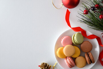 Assorted macaroons isolated on a white table with Christmas decoration
