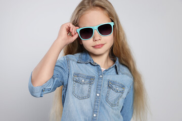 Naklejka premium Girl in stylish sunglasses on light grey background