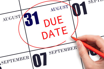 Hand writing text DUE DATE on calendar date August 31 and circling it. Payment due date